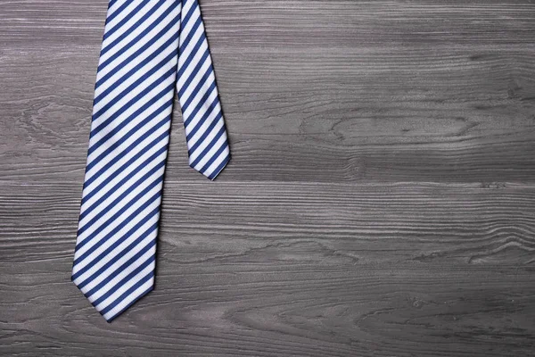Cravate élégante en soie rayée sur table en bois gris foncé, vue du dessus avec espace pour le texte — Photo