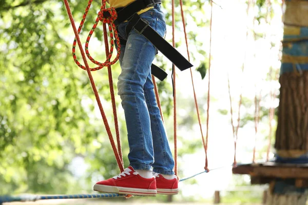 Liten flicka klättring i äventyrspark. Sommarläger — Stockfoto