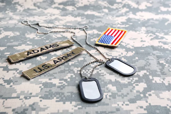 Military ID tags and US army patches on camouflage background — Stock Photo, Image