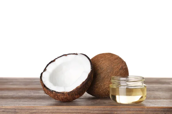 Cocos y frasco de aceite orgánico natural sobre mesa de madera sobre fondo blanco — Foto de Stock