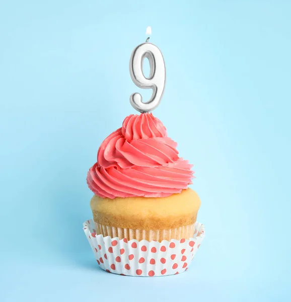 Cupcake d'anniversaire avec numéro neuf bougie sur fond bleu — Photo