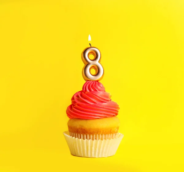 Cupcake d'anniversaire avec numéro huit bougie sur fond jaune — Photo