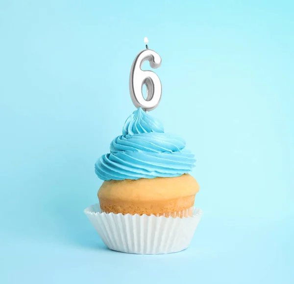 Cupcake d'anniversaire avec numéro six bougie sur fond bleu — Photo