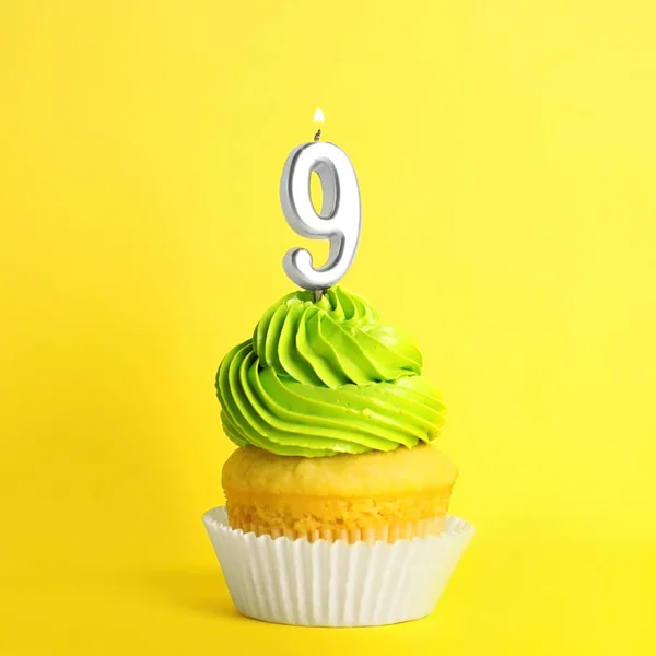 Cupcake d'anniversaire avec numéro neuf bougie sur fond jaune — Photo