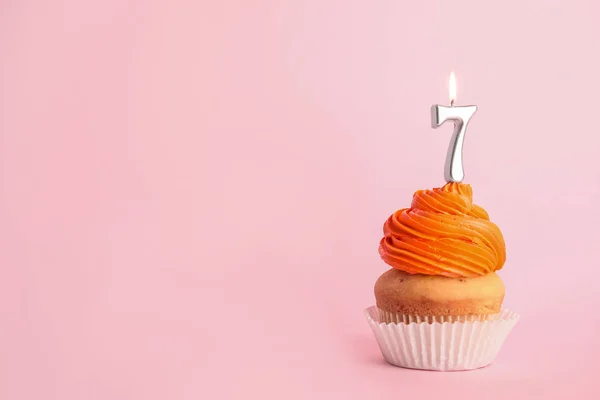 Cupcake d'anniversaire avec numéro sept bougie sur fond rose, espace pour le texte — Photo