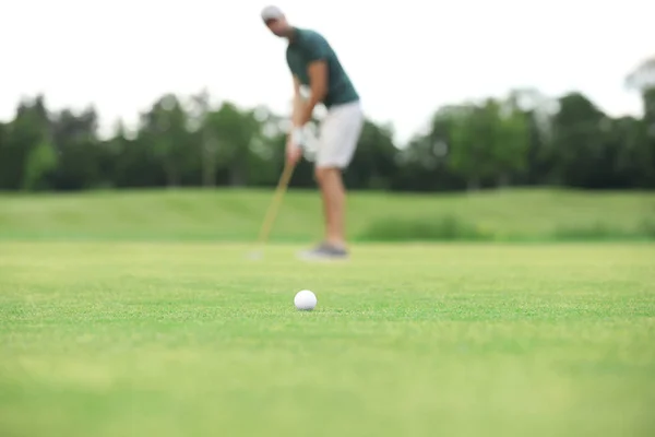 Muž, který hraje golf na zeleném hřišti, míč zaměřen. Sport a volný čas — Stock fotografie