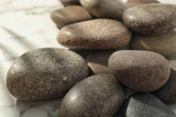Hromada lázeňských kamenů na mramorovém stole, zaostřená — Stock fotografie