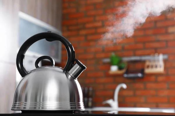 Modern kettle with whistle on stove in kitchen, space for text — Stock Photo, Image
