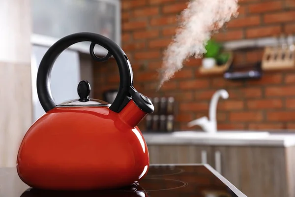 Modern kettle with whistle on stove in kitchen, space for text — Stock Photo, Image