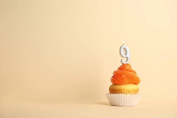 Cupcake d'anniversaire avec numéro neuf bougie sur fond beige, espace pour le texte — Photo