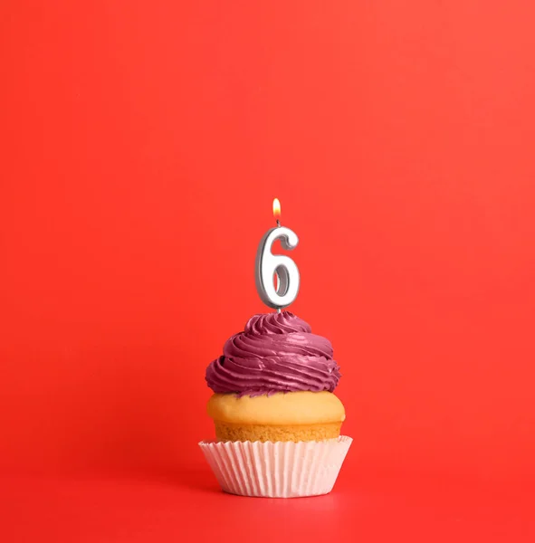Cupcake d'anniversaire avec numéro six bougie sur fond rouge — Photo