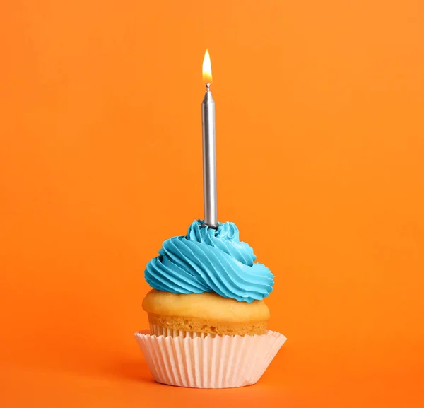 Urodzinowa ciastko ze świecą na pomarańczowym tle — Zdjęcie stockowe