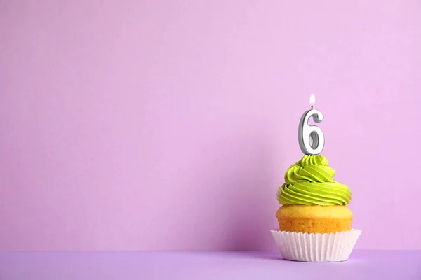 Cupcake d'anniversaire avec numéro six bougie sur fond violet, espace pour le texte — Photo