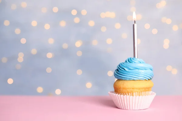 Magdalena de cumpleaños con vela en la mesa contra las luces festivas, espacio para el texto —  Fotos de Stock