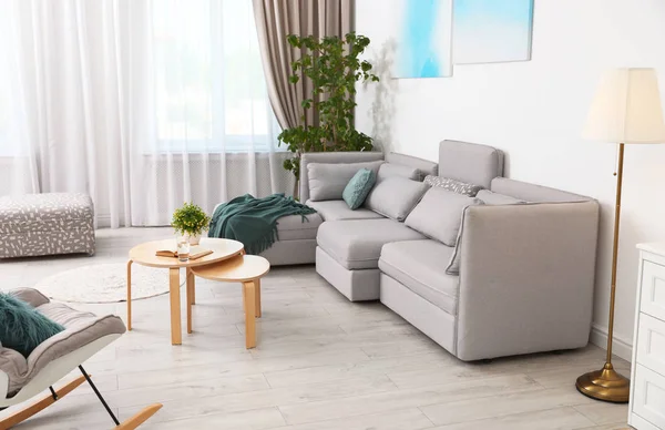 Modern oturma odasının içi rahat kanepeyle dolu.