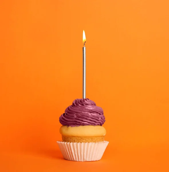 День рождения кекс со свечой на оранжевом фоне — стоковое фото