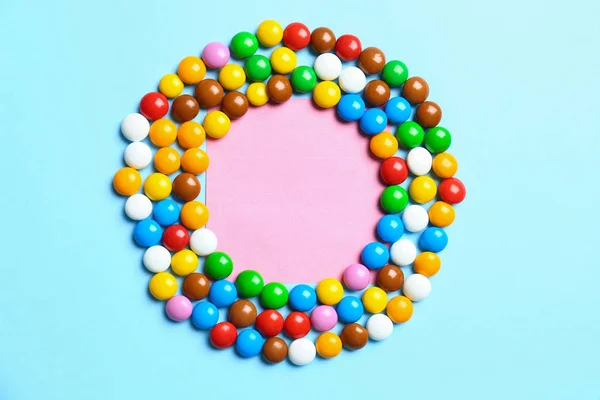 Рамка з смачних цукерок на кольоровому фоні, вид зверху. Простір для тексту — стокове фото