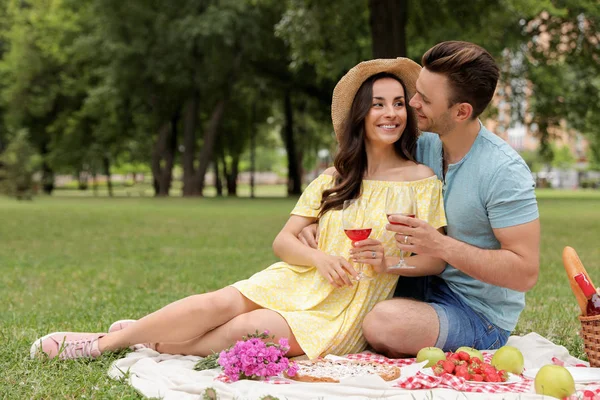 Feliz pareja joven haciendo un picnic en el parque en el día de verano — Foto de Stock