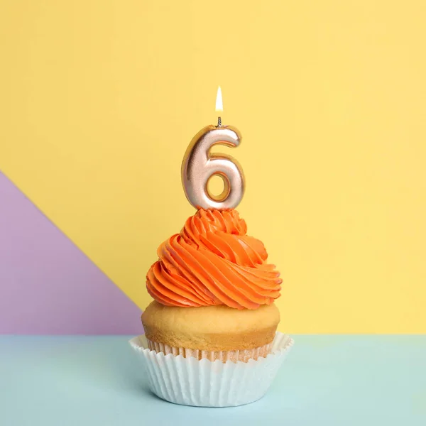 Cupcake d'anniversaire avec numéro six bougie sur fond de couleur — Photo