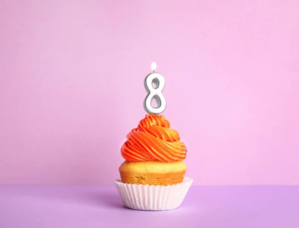 Cupcake d'anniversaire avec numéro huit bougie sur fond violet — Photo