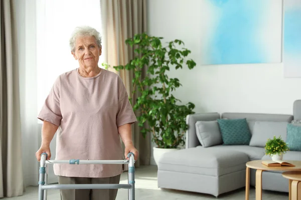 Oudere vrouw met Walking frame binnenshuis. Ruimte voor tekst — Stockfoto