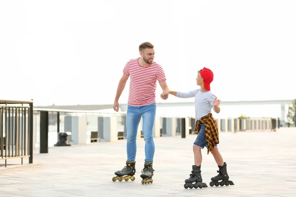 Vater und Sohn beim Rollschuhlaufen auf der Stadtstraße — Stockfoto