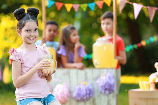 Söt liten flicka med naturlig lemonad i parken, utrymme för text. Sommar uppfriskande drink — Stockfoto