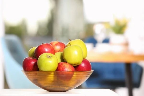 Bol avec différentes pommes sucrées sur la table dans la chambre, espace pour le texte — Photo