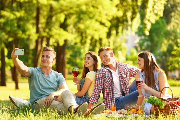 Jonge mensen genieten van picknick in Park op zomerdag — Stockfoto