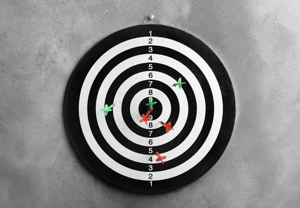Arrows hitting dart board on grey wall — Stock Photo, Image