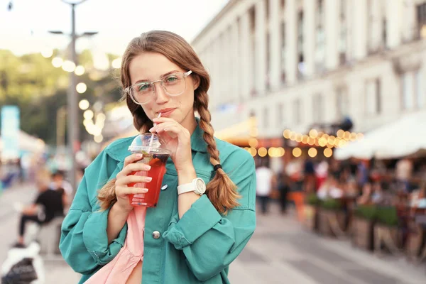 在城市街道上喝清凉饮料的年轻女子。文本空间 — 图库照片