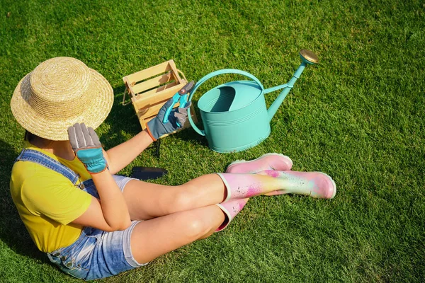 Wanita muda dengan alat berkebun di rumput hijau — Stok Foto