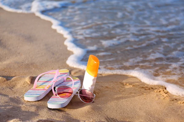 Flip papucs és strand kiegészítők a homok közelében tenger. Szóköz a szöveghez — Stock Fotó