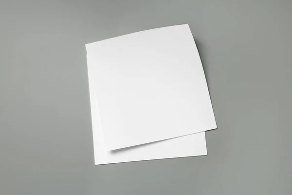 Blank paper sheets for brochure on grey background, top view. Mock up — Stock Photo, Image