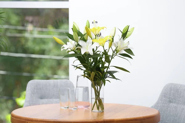 실내 나무 테이블에 아름다운 백합의 꽃다발 꽃병 — 스톡 사진