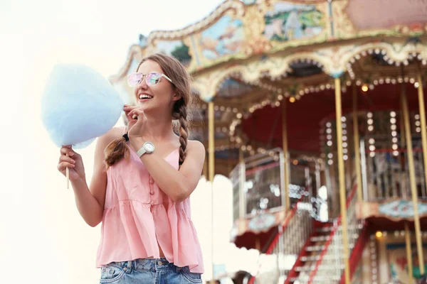 Junge Frau mit Zuckerwatte im Freizeitpark. Raum für Text — Stockfoto