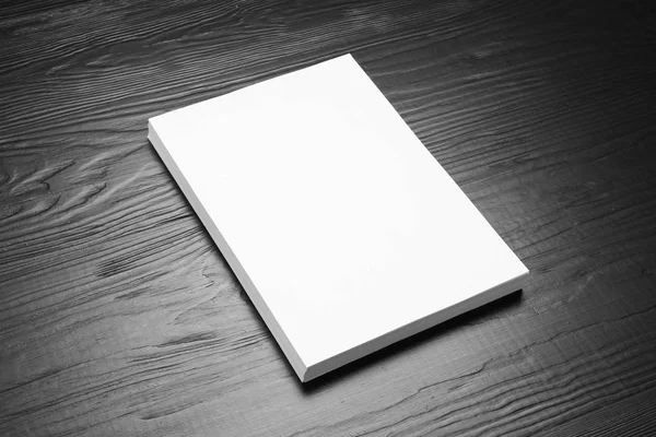 Pilha de folhas de papel em branco para brochura sobre fundo de madeira preta. Faz asneira. — Fotografia de Stock