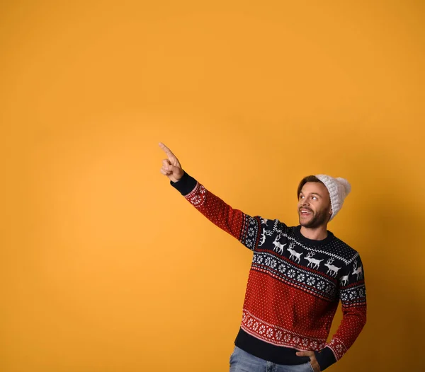 Giovane uomo in maglione di Natale e cappello su sfondo giallo. Spazio per testo — Foto Stock