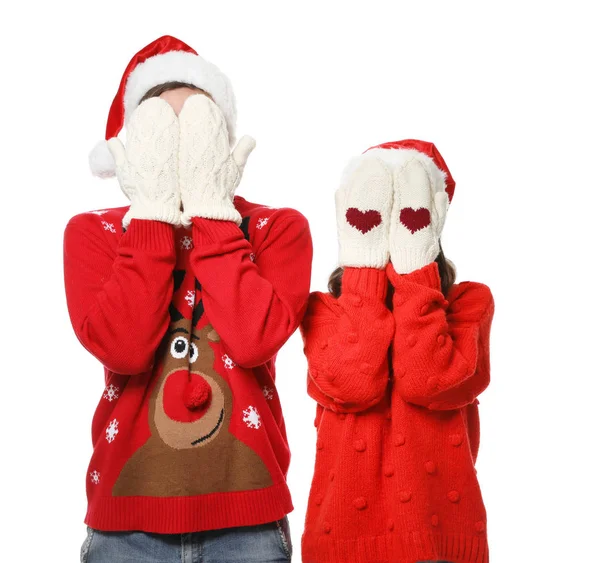 Mladý pár na vánočních svetry a klobouky na bílém pozadí — Stock fotografie