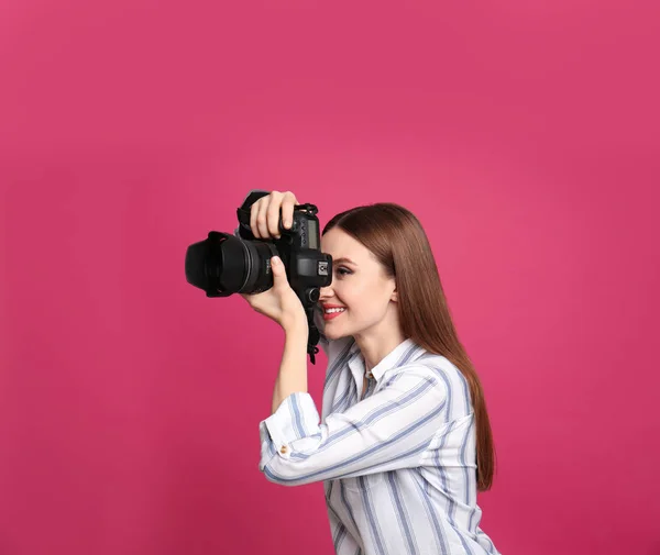 Fotógrafo profissional tirando fotos em fundo rosa — Fotografia de Stock