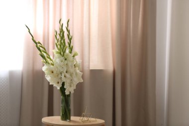Odada ahşap masa üzerinde güzel beyaz gladiolus çiçek ile Vazo, metin için alan