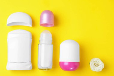 Sarı arka plan üzerinde farklı kadın deodorantlar ile düz yatıyordu kompozisyon, metin için alan
