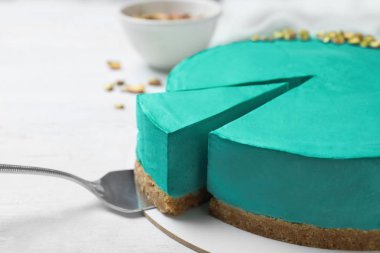 Beyaz ahşap arka plan üzerinde lezzetli ev yapımı spirulina cheesecake