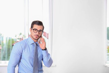 Yakışıklı genç adam işyerinde telefonda konuşurken, metin için alan