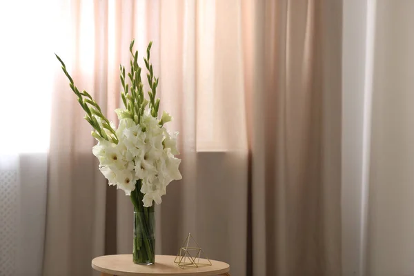 Vas dengan indah bunga gladiolus putih di atas meja kayu di kamar, ruang untuk teks — Stok Foto