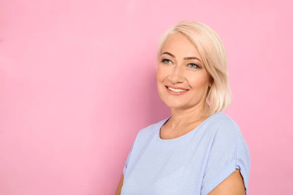 Retrato de mulher madura com rosto bonito no fundo rosa. Espaço para texto — Fotografia de Stock