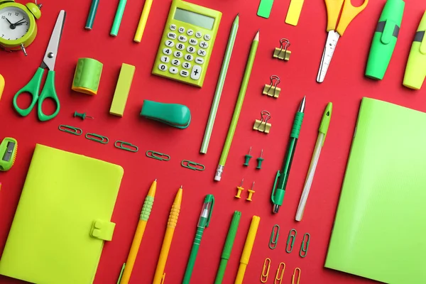 Papelaria escola verde em fundo vermelho, flat lay — Fotografia de Stock