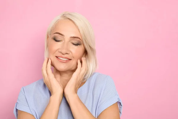 Retrato de mujer madura con cara hermosa sobre fondo rosa. Espacio para texto —  Fotos de Stock