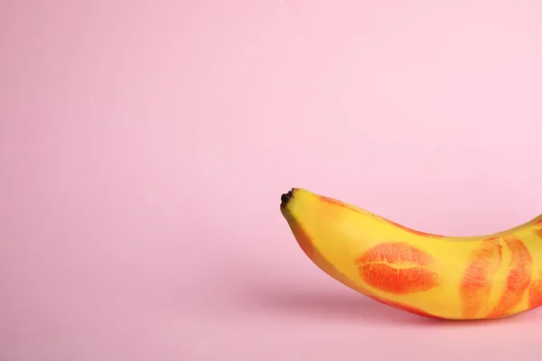 新鲜的香蕉与红色口红标记在粉红色的背景，文本的空间。概念 — 图库照片
