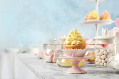 Beyaz mermer masa, metin için alan cupcake ve diğer tatlılar ile standı. Şeker çubuğu